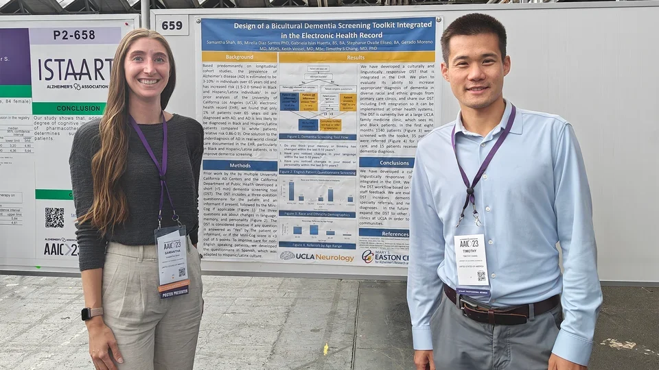 2023 AAIC-Chang Lab, Samantha Shah and Dr. Timothy Chang standing in front of their poster board smiling 