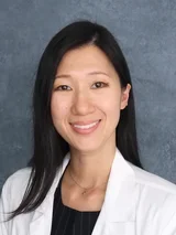 Marie Kim, MD, PhD, female in white coat, smiling for professional profile.