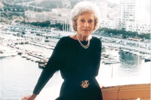 Mrs. Mary S. Easton, an elderly classy lady photo on a higher ground with water and boats in the background.