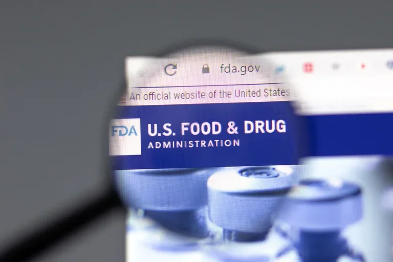 US Food and Drug magnified with medication in the background.