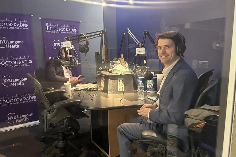 male in studio looking back smiling.