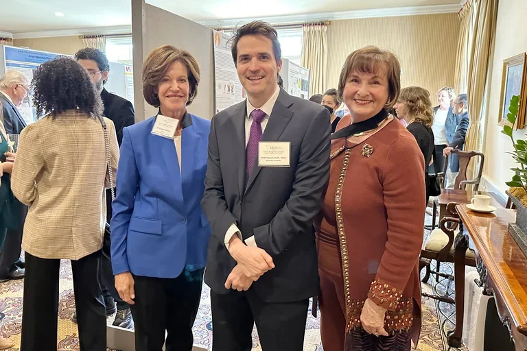Three professionals smiling at an event
