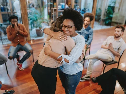 Young support group women hugging