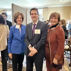 Three professionals smiling at an event
