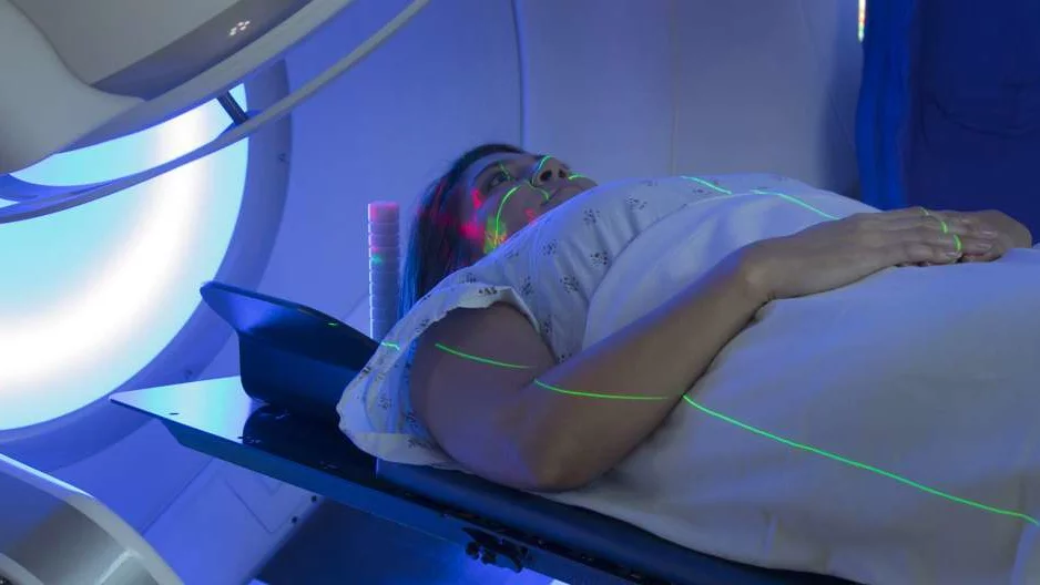 Photo of patient in MRI device with assisting Radiologist 